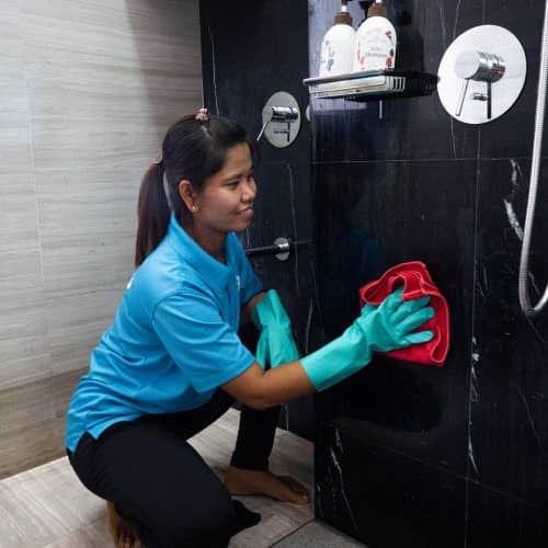 A Sureclean employee is deep cleaning the shower room