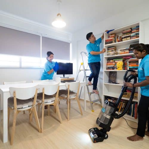 Three Sureclean employees are deep cleaning the living room